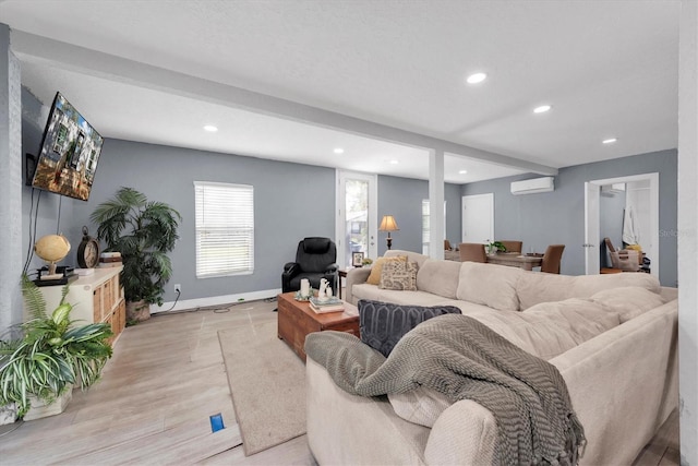 living room featuring a wall mounted air conditioner and light wood-type flooring