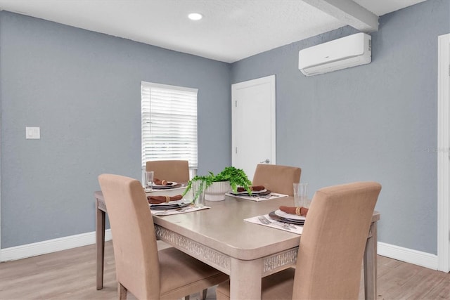 dining area with light hardwood / wood-style flooring and a wall mounted air conditioner