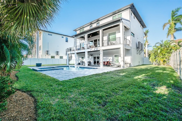 rear view of house featuring a patio, a balcony, a fenced in pool, and a lawn