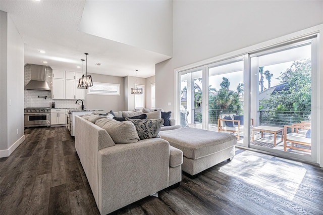 living room with plenty of natural light, a chandelier, dark hardwood / wood-style floors, and sink