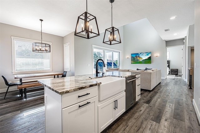 kitchen featuring a kitchen island with sink, dark wood-type flooring, sink, pendant lighting, and white cabinetry