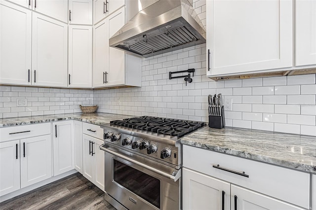 kitchen with high end stainless steel range, dark wood-type flooring, range hood, and tasteful backsplash