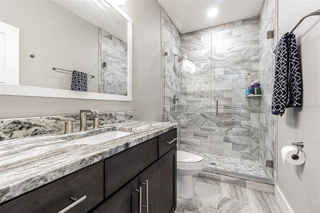 bathroom featuring vanity, toilet, and a shower with shower door