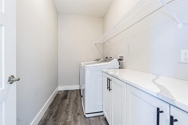 clothes washing area featuring washer and clothes dryer, dark hardwood / wood-style floors, cabinets, and a textured ceiling