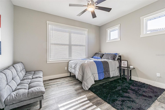 bedroom with multiple windows, ceiling fan, and light hardwood / wood-style floors