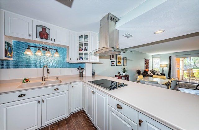 kitchen with backsplash, sink, black electric cooktop, white cabinetry, and island exhaust hood