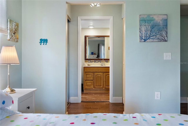 bedroom featuring hardwood / wood-style flooring and ensuite bath