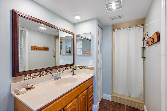 bathroom with vanity, wood-type flooring, backsplash, and curtained shower