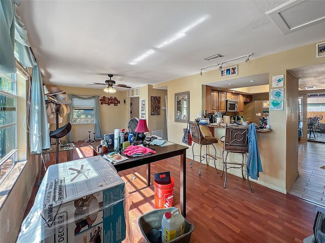 dining space with ceiling fan, hardwood / wood-style floors, and track lighting