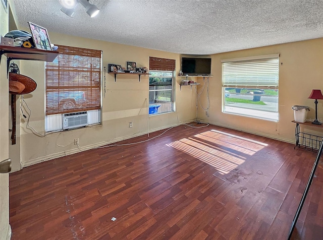 spare room with dark hardwood / wood-style floors, cooling unit, and a textured ceiling