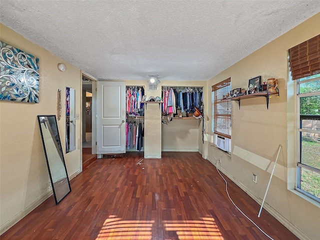 spare room featuring plenty of natural light, cooling unit, dark hardwood / wood-style flooring, and a textured ceiling