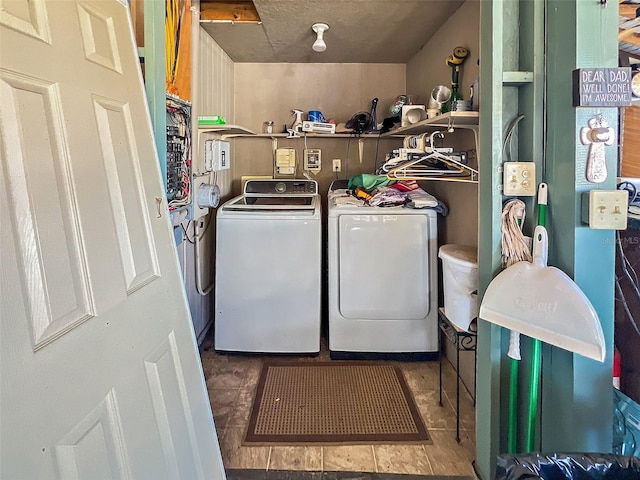 washroom with a textured ceiling, dark tile patterned flooring, and washing machine and clothes dryer