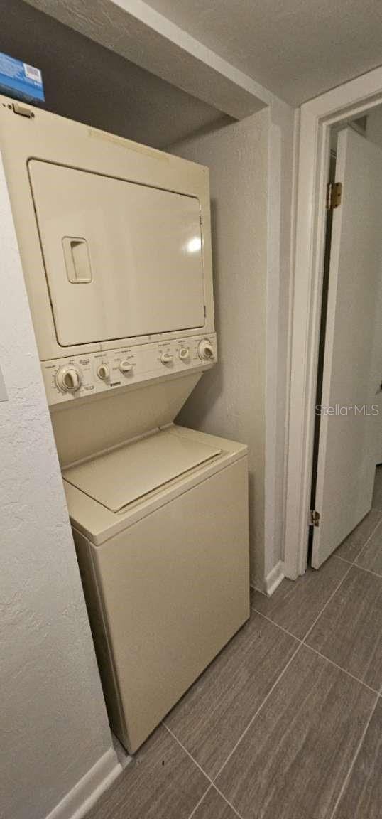 clothes washing area with stacked washer and clothes dryer