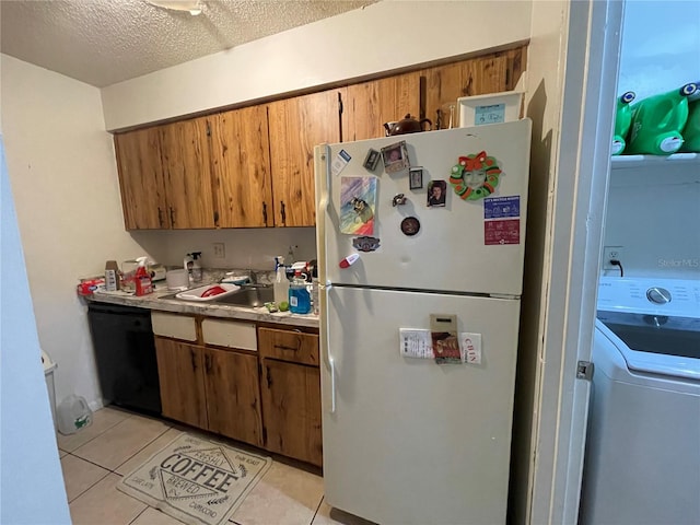 kitchen featuring dishwasher, white refrigerator, light tile patterned floors, a textured ceiling, and washer / dryer