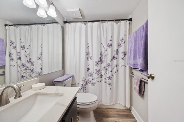 full bath featuring toilet, curtained shower, wood finished floors, and vanity