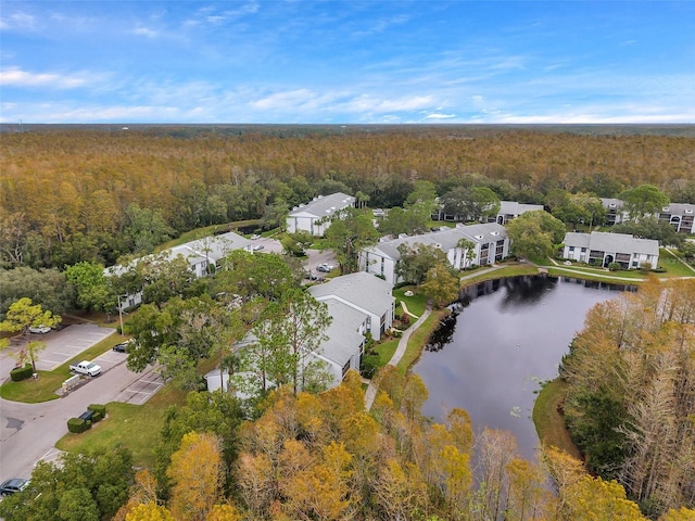 aerial view with a residential view, a water view, and a view of trees