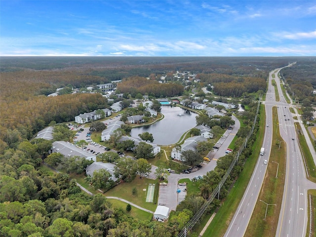 aerial view with a water view and a wooded view