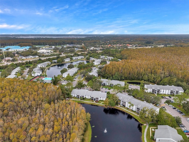 drone / aerial view with a residential view, a water view, and a view of trees