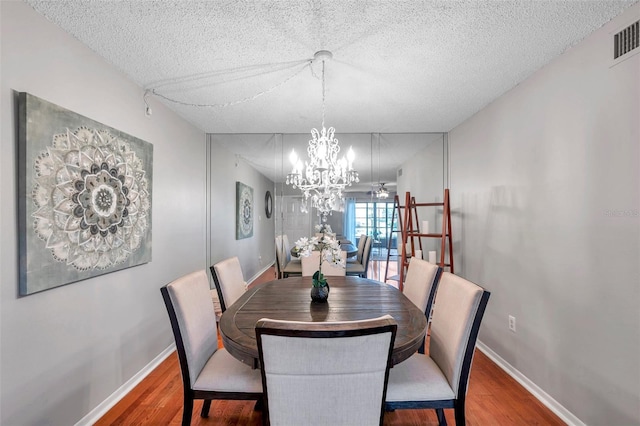 dining room featuring wood finished floors, visible vents, and baseboards