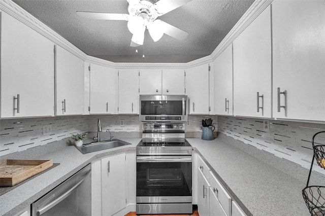 kitchen featuring a textured ceiling, stainless steel appliances, a sink, and light countertops