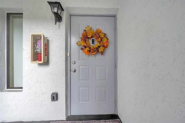 entrance to property featuring stucco siding