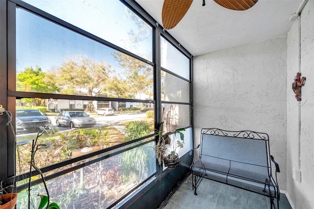 unfurnished sunroom featuring a ceiling fan