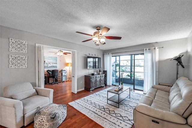 living area featuring dark wood-style floors, ceiling fan, baseboards, and a textured ceiling