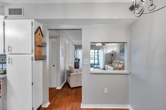 interior space with baseboards, visible vents, and dark wood-type flooring