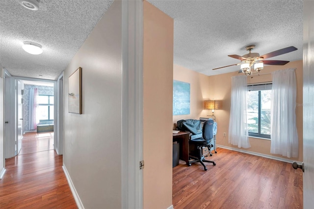 office featuring a wealth of natural light, baseboards, and wood finished floors