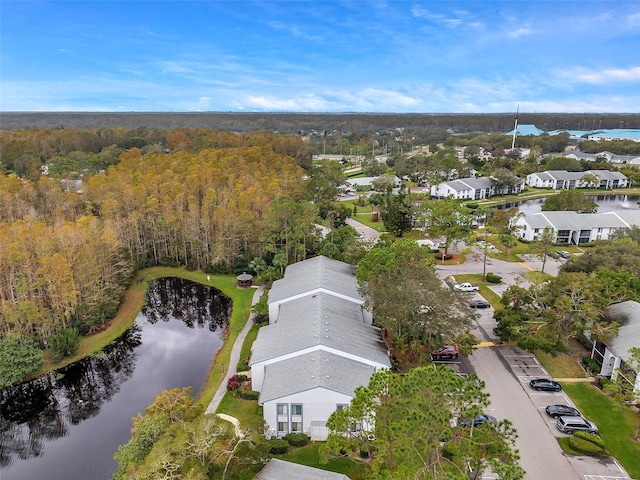 drone / aerial view with a water view, a wooded view, and a residential view