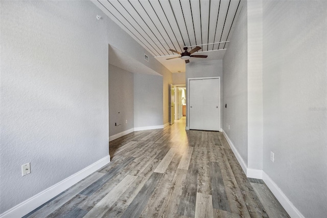 spare room with ceiling fan, a high ceiling, and hardwood / wood-style flooring