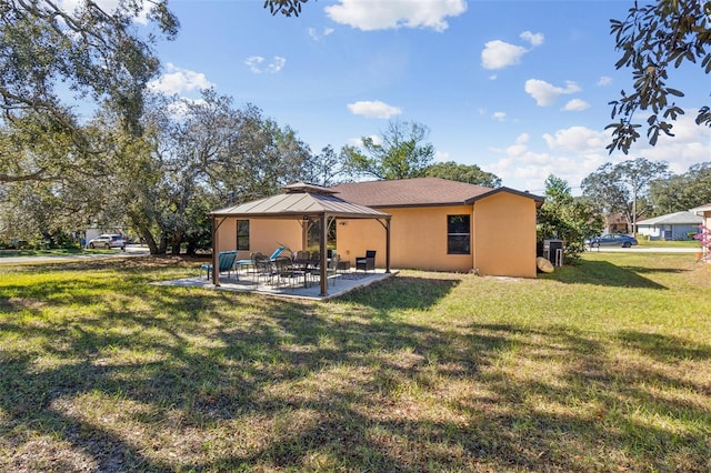 rear view of house with a gazebo, a patio, and a lawn