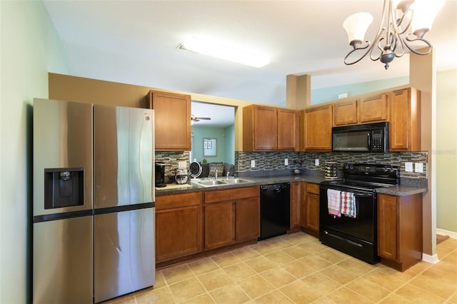 kitchen featuring sink, pendant lighting, backsplash, and black appliances