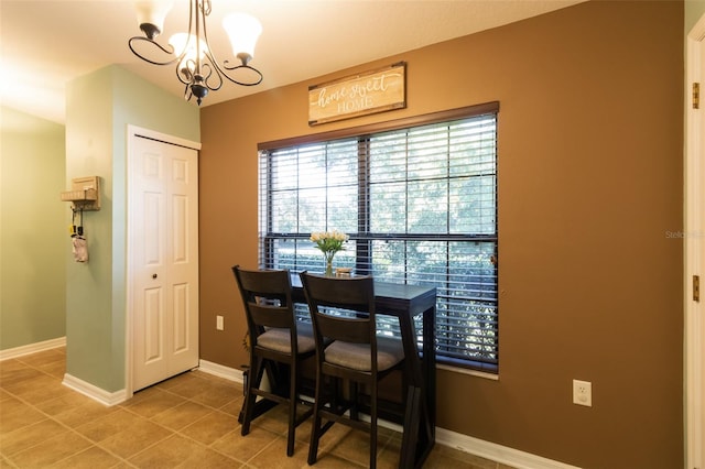 tiled dining room featuring an inviting chandelier