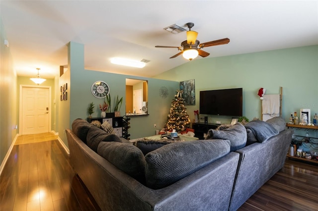 living room featuring ceiling fan, dark wood-type flooring, and vaulted ceiling