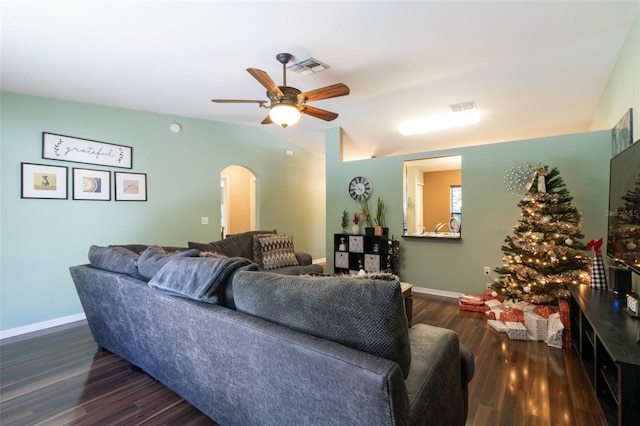 living room with ceiling fan, dark hardwood / wood-style flooring, and vaulted ceiling