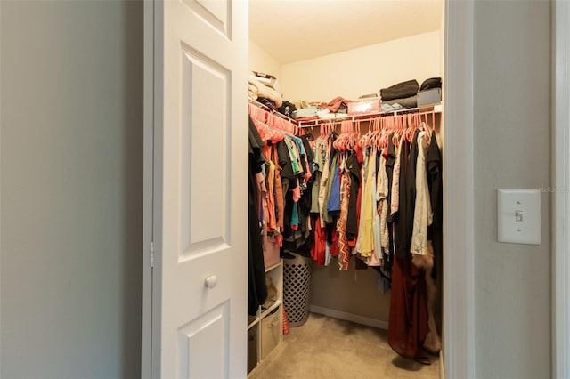 walk in closet featuring light carpet