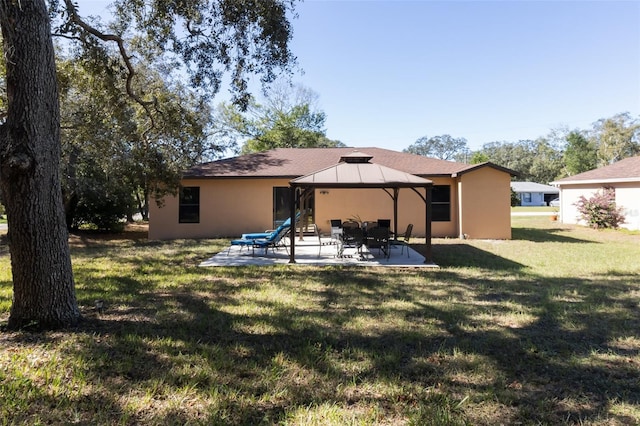 rear view of house with a gazebo, a patio area, and a yard