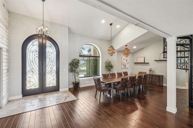 dining area with wood finished floors, arched walkways, a notable chandelier, and french doors