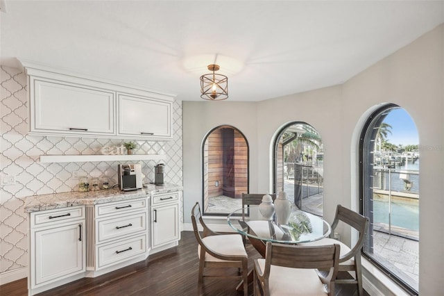 dining area with dark wood-style flooring and baseboards