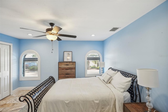 bedroom with baseboards, multiple windows, visible vents, and a closet