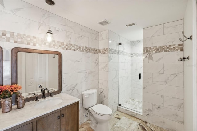 bathroom with tile walls, visible vents, toilet, a stall shower, and vanity