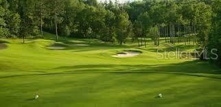 view of property's community featuring golf course view and a lawn