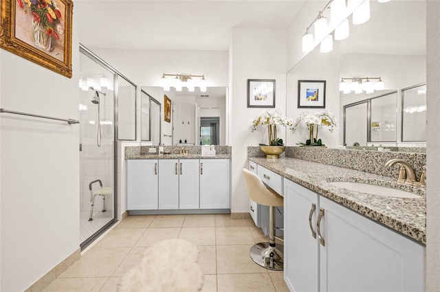 bathroom with tile patterned flooring, vanity, and a shower with door