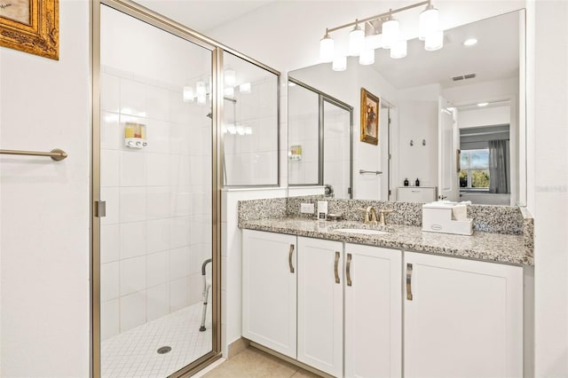 bathroom featuring tile patterned floors, vanity, and a shower with door