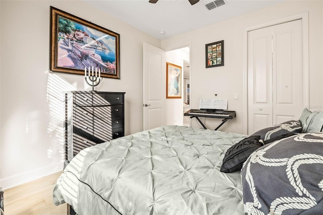 bedroom featuring ceiling fan, light hardwood / wood-style floors, and a closet