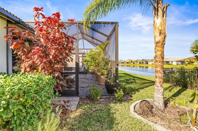 view of yard featuring glass enclosure and a water view