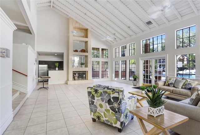 living room with a tile fireplace, wooden ceiling, beamed ceiling, high vaulted ceiling, and light tile patterned flooring