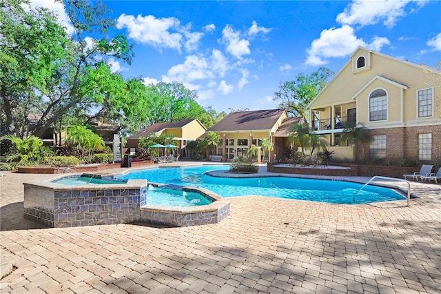 view of pool with a patio and a hot tub