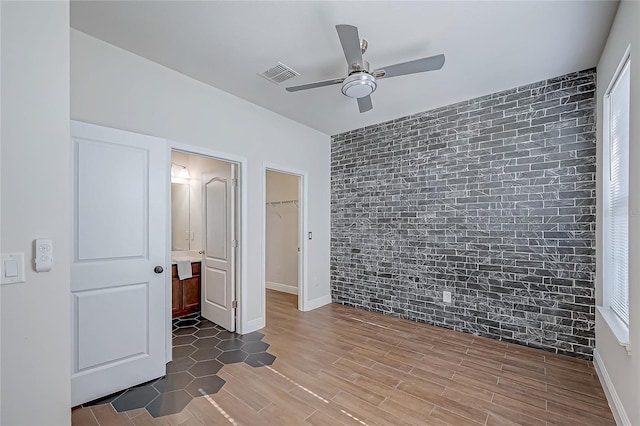 unfurnished bedroom with hardwood / wood-style floors, ceiling fan, a spacious closet, and a closet